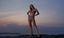Model wearing Rozal Active PowerFlex Deep V Bra and 3 inch High Waist Shorts in toffee beige on a beach at sunset – luxury sustainable activewear campaign.